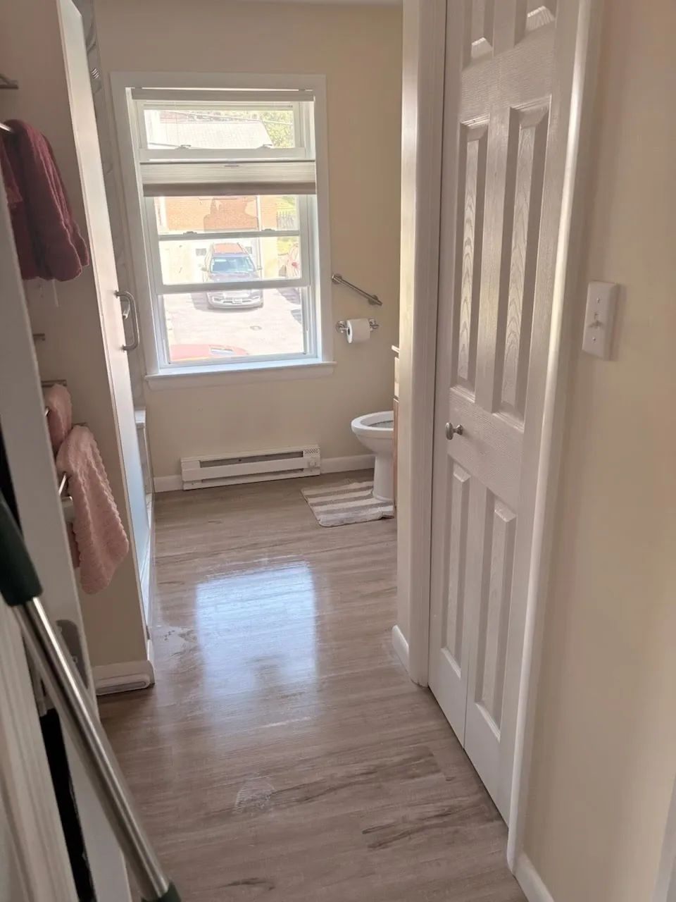 Cleaned bathroom with bright window, fresh floors, and tidy fixtures