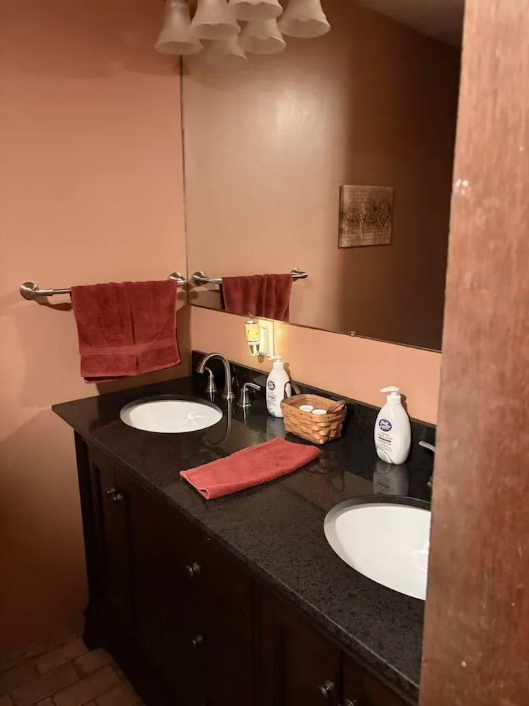 Spotless bathroom with double granite vanity and polished mirror
